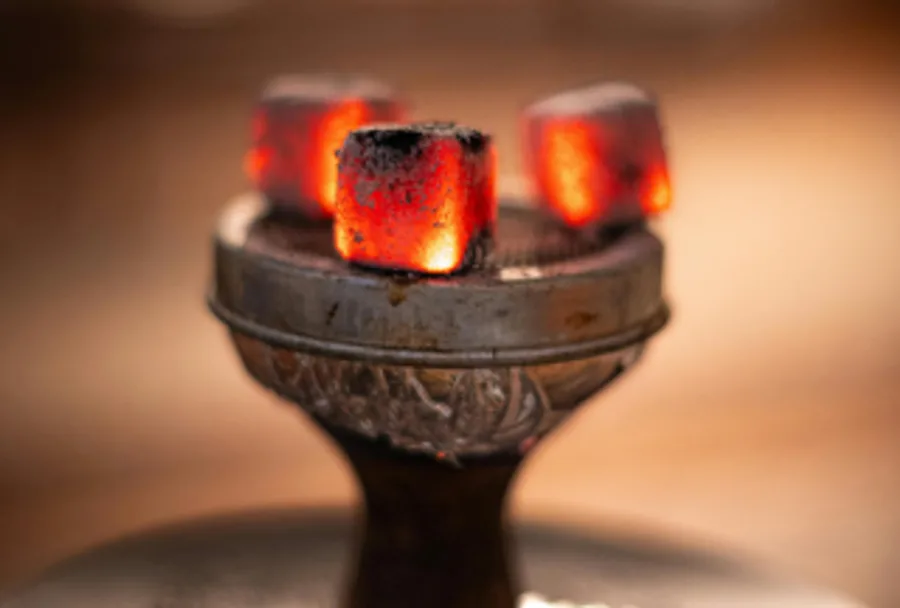 Coconut charcoal briquette cubes glowing on a shisha bowl